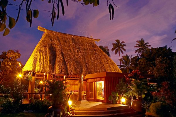 A bure lit up at night at Namale Resort Fiji